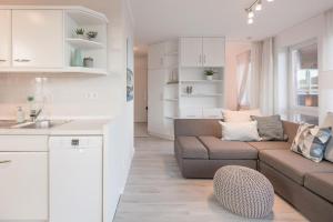 a kitchen and a living room with a couch at Waterkant in Husum