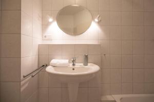 a white bathroom with a sink and a mirror at Waterkant in Husum