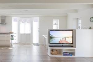 ein Wohnzimmer mit einem Flachbild-TV auf einem Stand in der Unterkunft Reethus Steuerbord Dagebüll in Dagebüll
