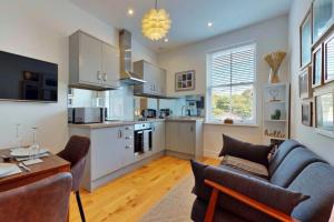 Una cocina y una sala de estar con un sofá y una mesa. en Finest Retreats - Peak Dale Apartment, en Matlock