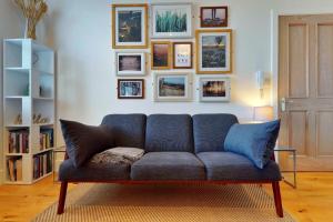 un sofá azul en una sala de estar con fotos en la pared en Finest Retreats - Peak Dale Apartment, en Matlock