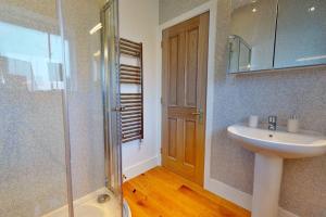 Un baño con lavabo y ducha de cristal. en Finest Retreats - Peak Dale Apartment, en Matlock