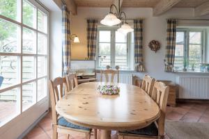 a dining room with a wooden table and chairs at Ferienhaus Geest auf Föhr in Borgsum +9 photos