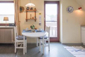 a white table and chairs in a room with a window at Ferienwohnung in Borgsum (oben rechts) in Borgsum