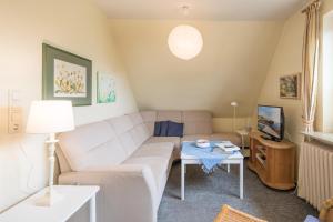 a living room with a couch and a table at Ferienwohnung in Borgsum (oben rechts) in Borgsum