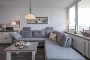 - un salon avec un canapé bleu et une table dans l'établissement Strandperle, à Wyk auf Föhr