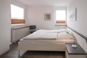 ヴィーク・アウフ・フェールにあるStrandperleの白いベッドルーム(ベッド1台、窓2つ付)