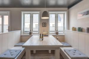 ein Esszimmer mit einem Tisch und einigen Fenstern in der Unterkunft Matthis Skipperhuus in Husum