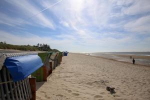 einen Strand mit einer Reihe von Unterkünften und Menschen darauf in der Unterkunft Kleine Perle in Wyk in Wyk auf Föhr