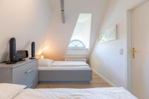 Schlafzimmer im Dachgeschoss mit 2 Betten und einem Fenster in der Unterkunft Kate am See in Uelvesbüll