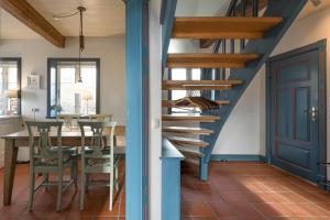 a blue staircase in a dining room with a table at Reethus Schobüll in Husum