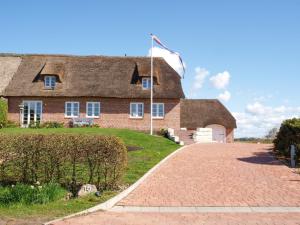 uma grande casa de tijolos com uma bandeira numa entrada em Haus Inge em Dagebüll