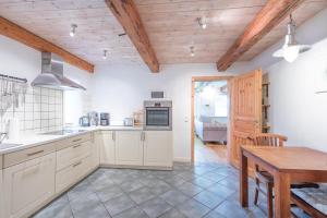 a kitchen with white cabinets and a wooden ceiling at Wellnesswarft Waygaard Ost in Dagebüll