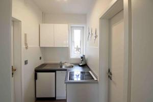 a small kitchen with a sink and a window at Apartment Roock in Wyk auf Föhr