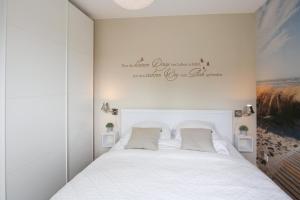 フーズムにあるIn der Schlossstraßeのベッドルーム1室(白いベッド1台、壁に看板付)