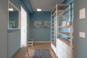 a room with blue walls and a white shelf at Ankerzeit in Husum