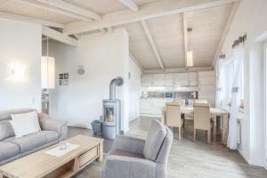 a kitchen and living room with a table and chairs at Ferienhaus Steinwälzer in Dagebüll