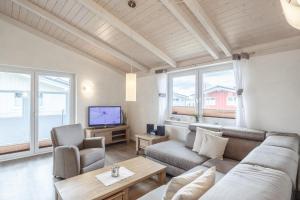 a living room with a couch and a tv at Ferienhaus Strandkrabbe in Dagebüll