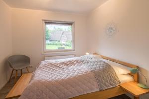 Schlafzimmer mit einem Bett und einem Fenster in der Unterkunft Villa Lütt-KEINE MONTEURE- in Husum