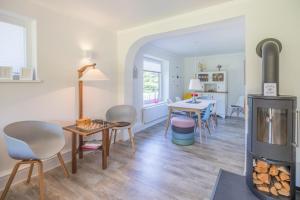 ein Wohnzimmer mit einem Holzofen und einem Esszimmer in der Unterkunft Villa Lütt-KEINE MONTEURE- in Husum