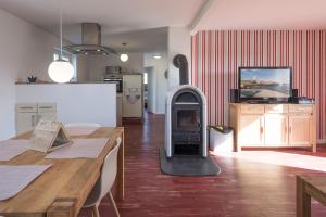 een woonkamer met een houtkachel in het midden van de kamer bij Altes Schäferhaus in Nordstrand