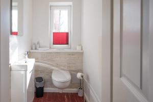 een witte badkamer met een toilet en een raam bij Altes Schäferhaus in Nordstrand +8 foto's