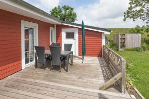 een houten terras met een tafel en stoelen erop bij Altes Schäferhaus in Nordstrand