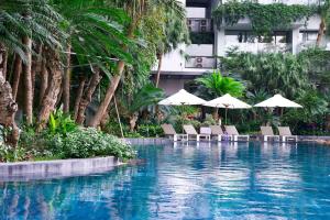 a swimming pool with chairs and umbrellas next to a building at Flamingo Resort Dai Lai in Ngọc Quang