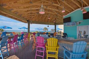 un restaurante con sillas coloridas y un bar en Ramada by Wyndham Panama City Beach / Beachfront, en Panama City Beach