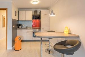 a kitchen with a table and a red refrigerator at Storm's Nest in Husum