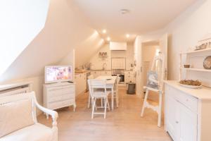 a kitchen and dining room with a table and chairs at Lille Weiss-KEINE MONTEURE- in Drelsdorf