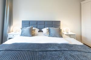 een slaapkamer met een groot bed met blauwe kussens bij Lütte Jung in Husum