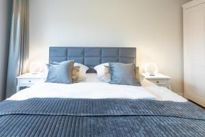 a bedroom with a large bed with blue pillows at Lütte Jung in Husum