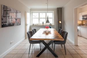 a dining room with a wooden table and chairs at Lütte Jung in Husum +4 photos