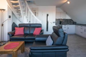 - un salon avec un canapé en cuir et une table dans l'établissement Käpt'n Cook 09, à Nordstrand