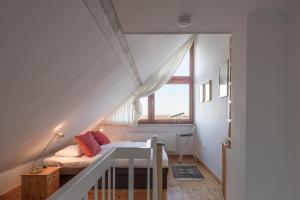 małą sypialnię na poddaszu z łóżkiem i oknem w obiekcie Käpt'n Cook 09 w mieście Nordstrand