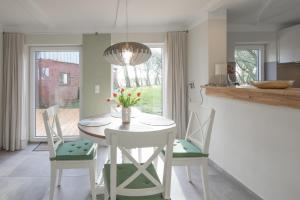 cocina y comedor con mesa y sillas en Haus Beltringharde, en Reußenköge