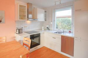a kitchen with white cabinets and a table and a window at Ferienhaus Bobby in Stahlbrode