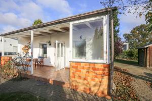 een huis met een groot raam en een houten terras bij Ferienhaus Bobby in Stahlbrode