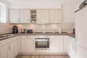 a white kitchen with white cabinets and an oven at Tine in Husum