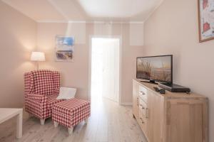 sala de estar con TV y silla en Tine, en Husum