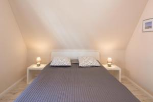 ein Schlafzimmer mit einem Bett mit zwei Kerzen darauf in der Unterkunft Tine in Husum