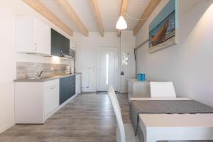 een keuken met witte kasten en een tafel in een kamer bij Fofteinbutze twee in Nordstrand