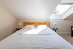a bedroom with a large white bed with a skylight at Alte Wassermuehle Hollebek in Bredstedt