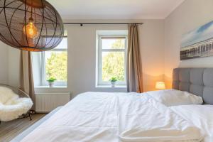 1 dormitorio con 1 cama blanca grande y 2 ventanas en Alte Wassermuehle Am Bach, en Bredstedt