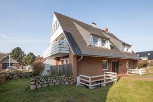 een bruin bakstenen huis met een stenen muur bij Seaside in Westerland