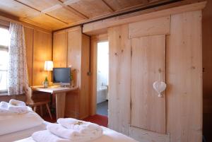 1 Schlafzimmer mit 2 Betten und einem Schreibtisch mit einem Computer in der Unterkunft Hotel Ducan in Monstein