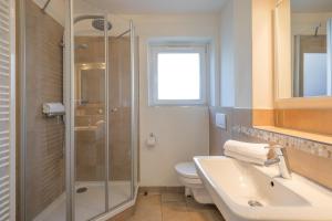 ein Bad mit einer Dusche, einem Waschbecken und einem WC in der Unterkunft Dat lütte Huus - Wohnung 2 in Husum