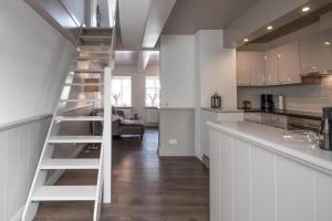a ladder leading up to a kitchen and a living room at Hannes Kapitänshaus in Husum