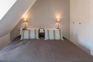 ein Schlafzimmer mit einem großen Bett mit zwei Kissen in der Unterkunft Hannes Kapitänshaus in Husum